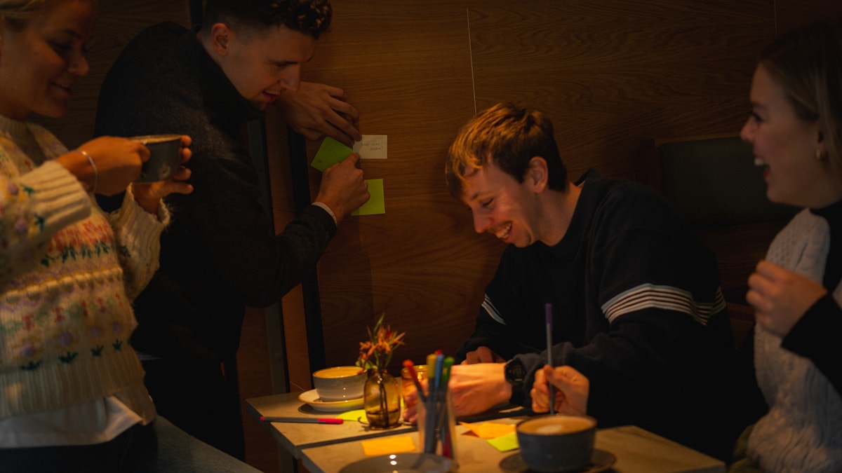 En kreativ gjeng med ansatte i Sneipfritt sitter rundt et bord, ler og smiler og kommer på ideer til Ballot bins.